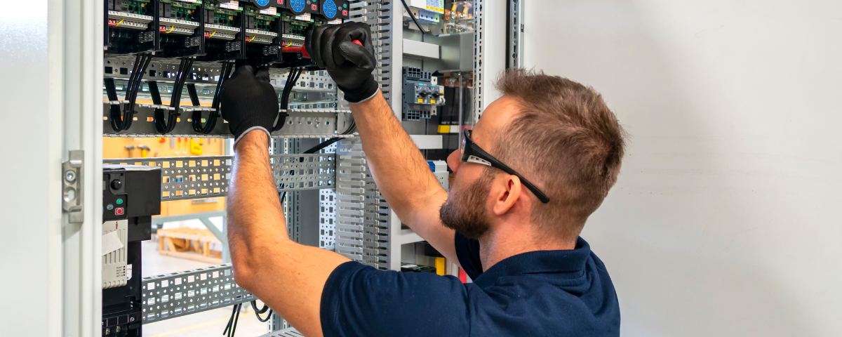 Electrician working at electric panel