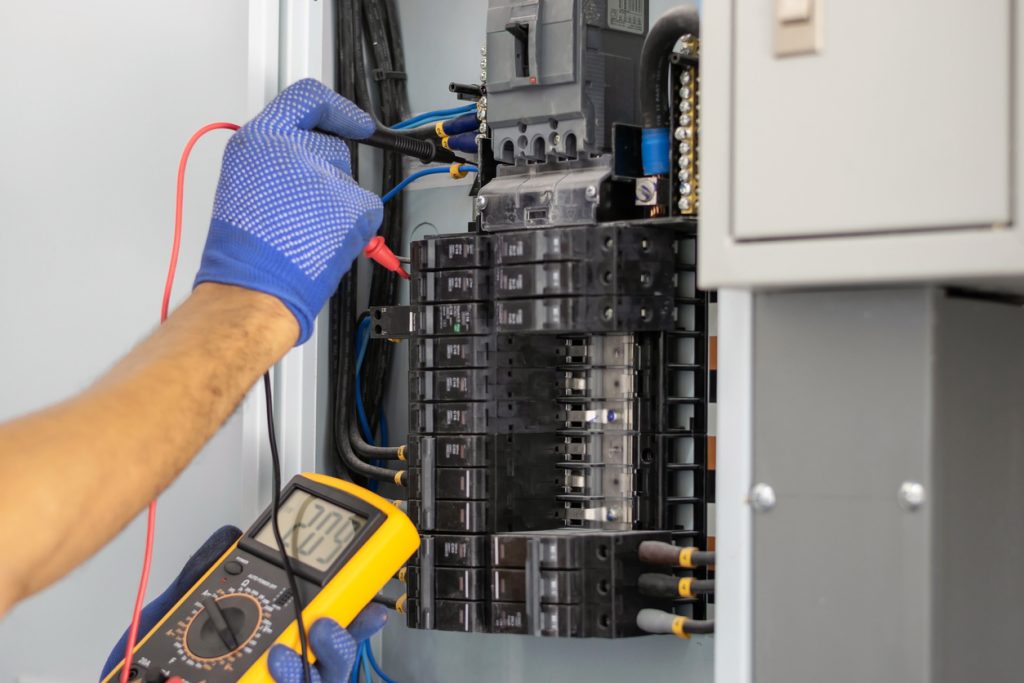 An electrician evaluates an electrical panel for upgrades to keep a residential home safe and functional.