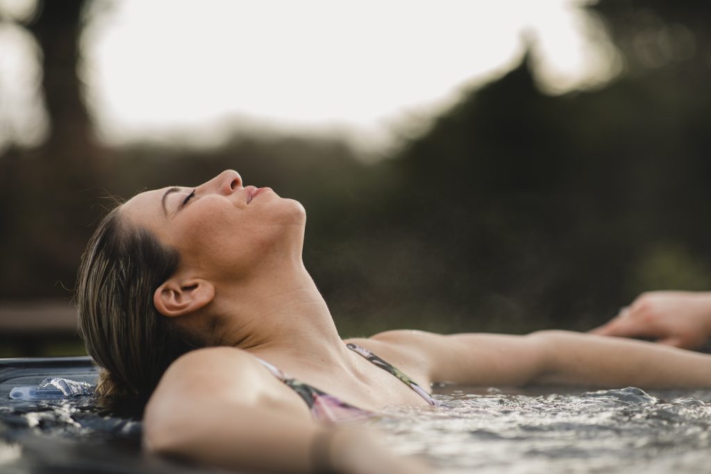 Photo of a woman relaxing in a hot tub after professional hot tub installation.