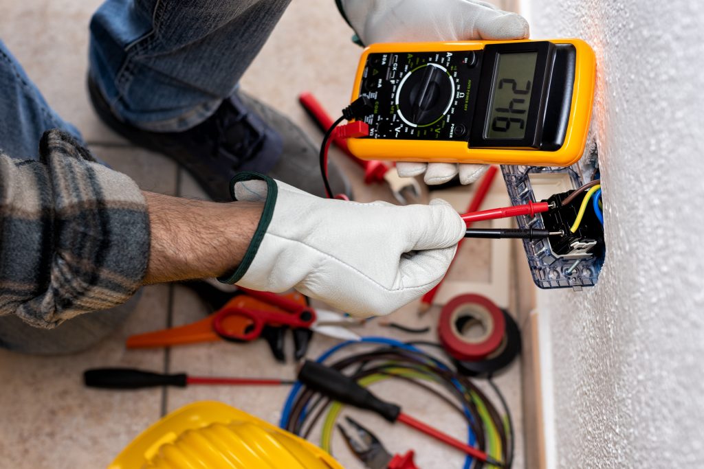 A licensed electrician checks the wattage of a GFCI outlet.
