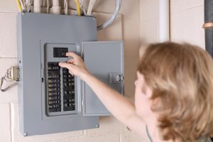 A homeowner inspects a residential circuit breaker panel after frequent tripping issues.