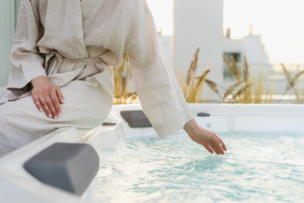 A woman tests the temperature in her full-size 240V hot tub.