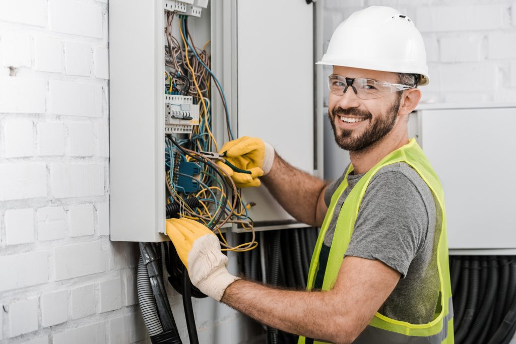 A professional electrician installing whole-home surge protection into an electrical box.