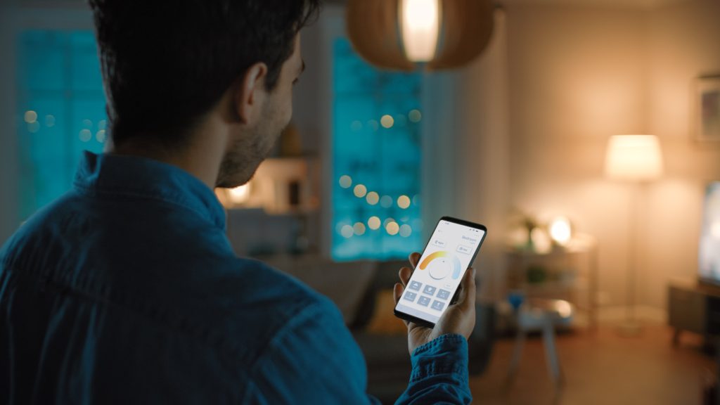 A homeowner adjusts the lighting in his home with a smart lighting app.